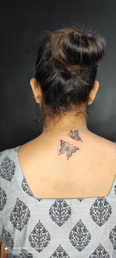 a woman with a butterfly tattoo on her neck