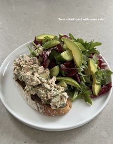 a white plate topped with a salad and an avocado on top of it