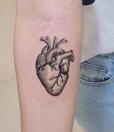 a small heart tattoo on the arm