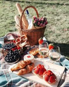 a picnic table with bread, fruit and wine