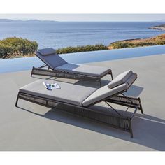 two chaise lounge chairs sitting on top of a patio