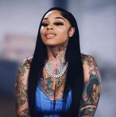 a woman with lots of tattoos on her body and chest, wearing a blue dress