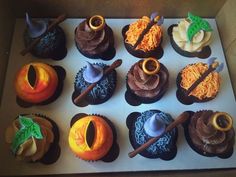 twelve cupcakes are decorated in different colors and designs, including one with an orange on top