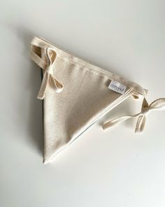 a small triangle shaped pouch with a ribbon tied around it