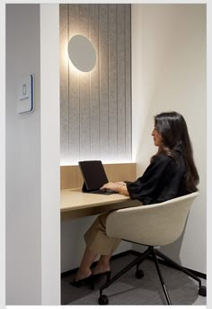 a woman sitting at a desk using a laptop computer