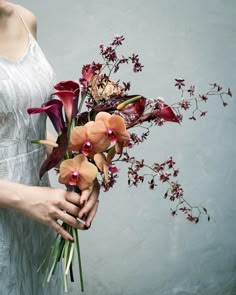 a woman holding a bouquet of flowers in her hands