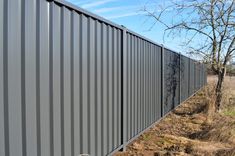 the side of a fence that is made out of metal sheeting and has been stripped off