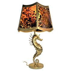 a lamp with a sea horse on it's base and a light shade in the shape of a lampshade