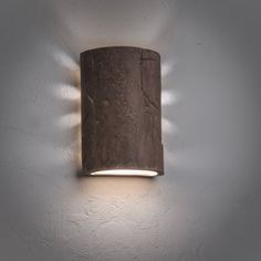 a wall light that is on the side of a white wall in a room with grey walls