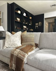 a living room filled with lots of furniture and pillows on top of a white couch