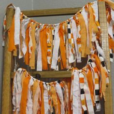 orange and white streamers are hanging from a ladder