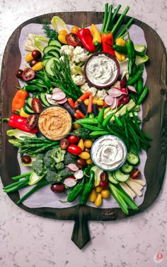 a platter filled with assorted veggies and dips