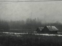 black and white photograph of an old barn in the fog