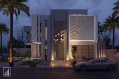 a car is parked in front of a modern house at night with palm trees around it