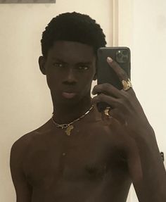 a shirtless man taking a selfie with his cell phone