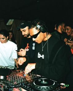 two men standing next to each other in front of a dj's turntable