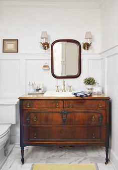 a bathroom with a sink, mirror and toilet in it's centerpieces