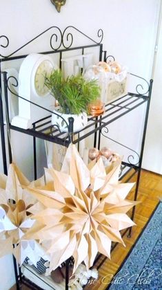 some paper flowers are sitting on a shelf next to a clock and other items in the room