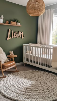 Modern nursery with an earthy green accent wall, white crib, and leather rocking chair. White Crib Green Wall Nursery, Dark Green And Cream Nursery, Green Paint Colors Nursery, Baby Boy Sage Green Nursery, Sage Green Safari Nursery, Boy Green Nursery, Green Yellow Nursery, Nursery Ideas Green, Green Baby Boy Nursery