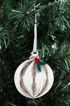 a white ornament hanging from a christmas tree