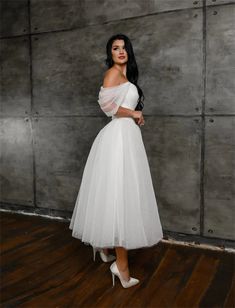 a woman in a white dress posing for the camera