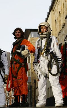 three people in spacesuits standing next to each other