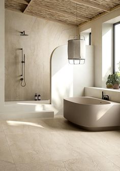 a bathroom with a tub, sink and window in the corner on the wall is an oval shaped bathtub