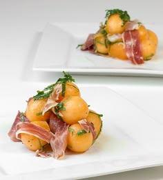 two white plates topped with food on top of a table