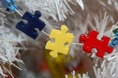 colorful pieces of puzzle hanging from a white christmas tree