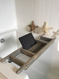 a bathtub with a laptop on it in a bathroom next to a starfish