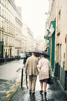 two people walking down the street with an umbrella