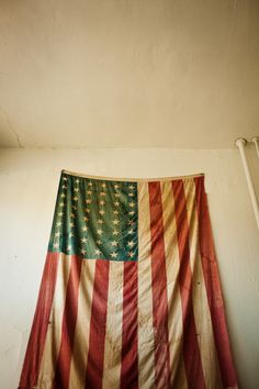 an old american flag hanging on the wall