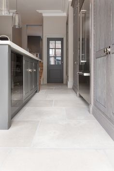 an instagram photo of a kitchen with grey cabinets and white flooring on the walls