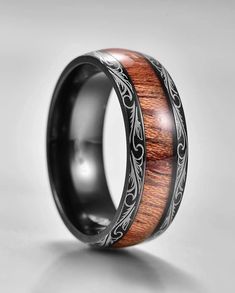 a wedding ring with wood and silver inlays on the inside, sitting on a white surface