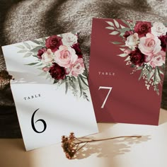 the table numbers are placed on top of each other, with flowers in front of them