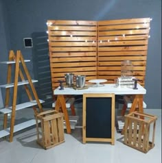 a table and chairs made out of pallet wood with lights on the back wall