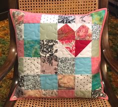 a colorful patchwork pillow sitting on top of a wooden chair