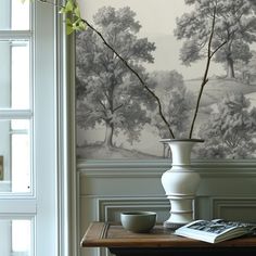 a vase filled with flowers sitting on top of a wooden table next to a window