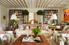 a living room filled with furniture and bookshelves covered in lots of bookcases