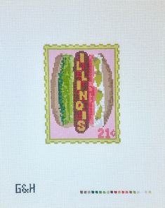 a cross stitch picture of a hamburger with lettuce and tomato on it's side