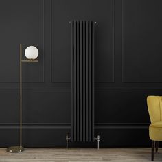 a black and gold radiator in a dark room with a yellow chair next to it