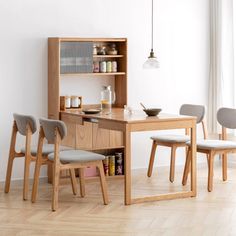 a dining room table with chairs and a book shelf on the wall next to it