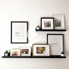 three black shelves with pictures and frames on them