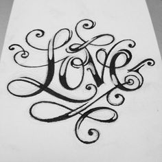 a piece of paper with the word love written on it in cursive writing