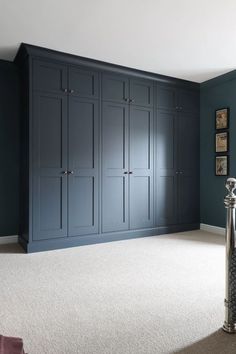 an empty room with blue cabinets and white carpet