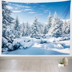 a wall hanging in a room with snow covered trees and blue sky behind it,