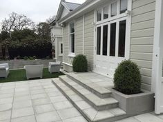 an outdoor patio with steps leading up to the front door and seating on either side