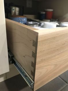 a kitchen cabinet door is open to reveal the drawers