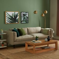 a living room with green walls and furniture in the corner, including a beige couch