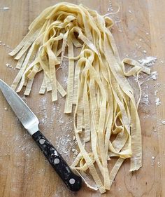 a knife and some pasta on a wooden table